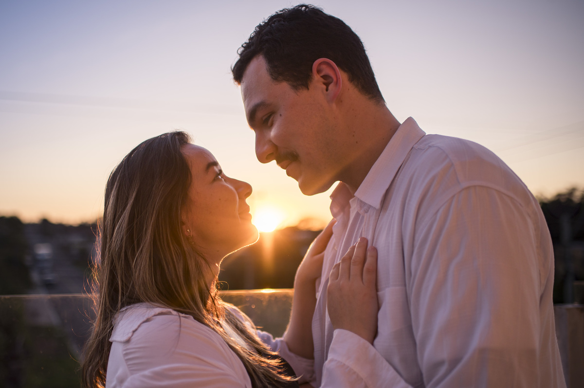ensaio de gestante em estúdio, foto na sacada com por do sol