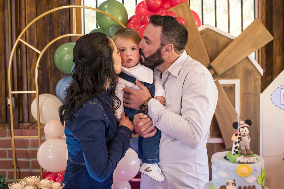 Festa de aniversário infantil, criança ganhando beijinho do pai e da mãe