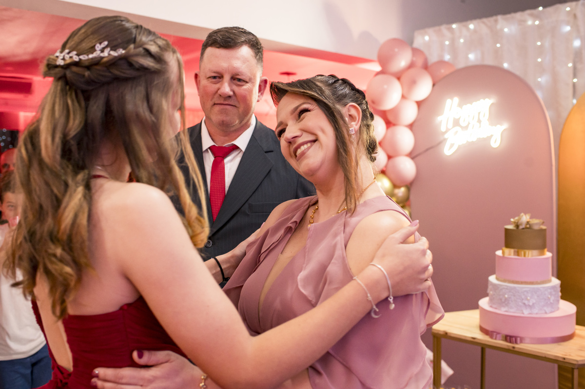 Festa de 15 anos, debutante ganhando abraço dos pais