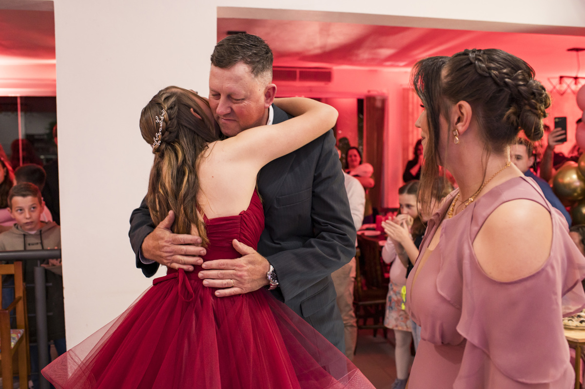 Festa de 15 anos, debutante ganhando abraço dos pais
