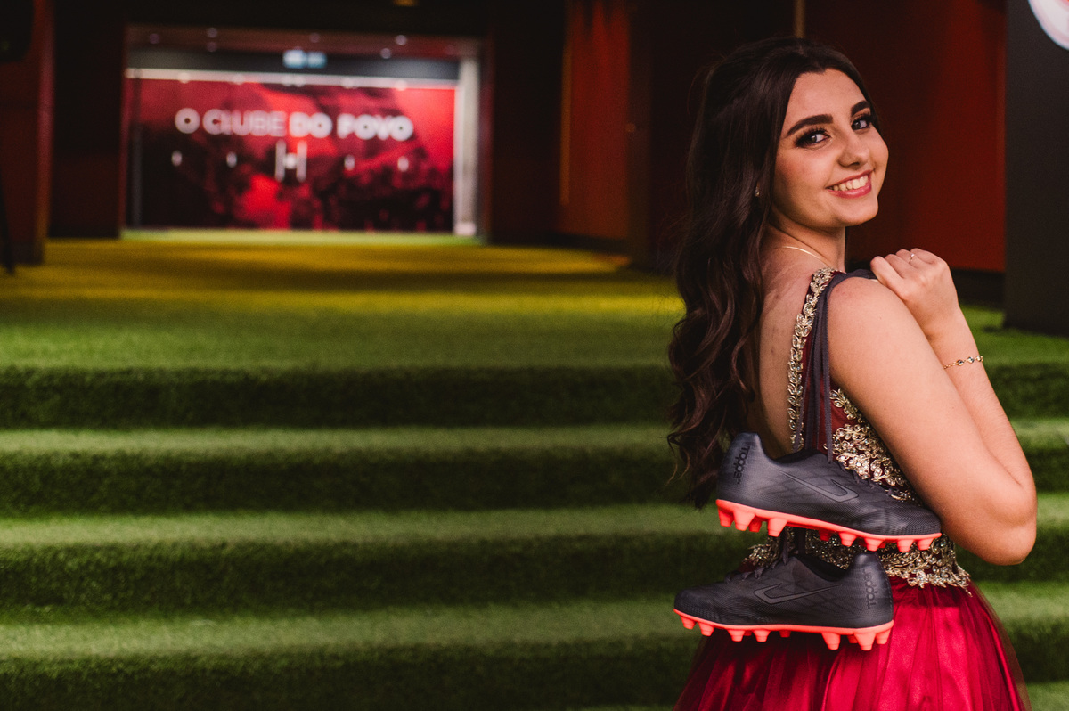 Ensaio fotográfico pré 15 anos no estádio Beira Rio - fotógrafa Claudia Wallauer - foto da debutante com as chuteiras na entrada do vestiário