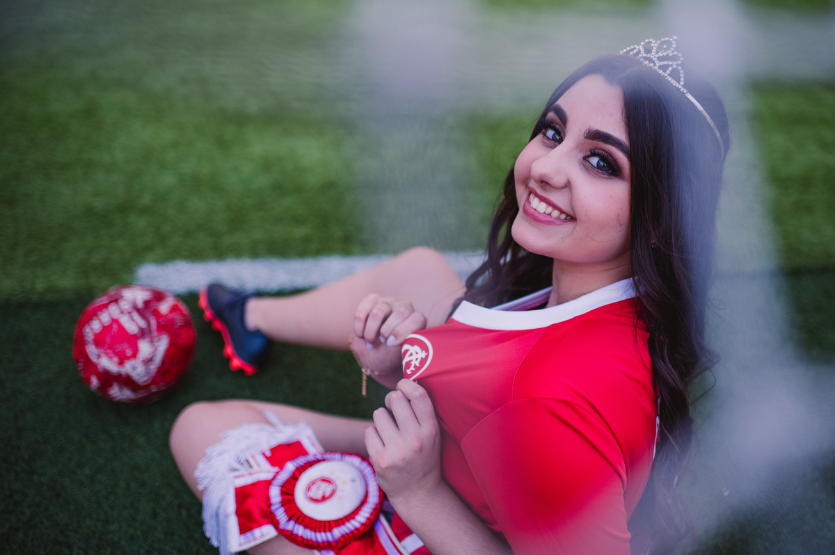 Ensaio fotográfico pré 15 anos no estádio Beira Rio - fotógrafa Claudia Wallauer - foto da debutante com camiseta do internacional e faixa