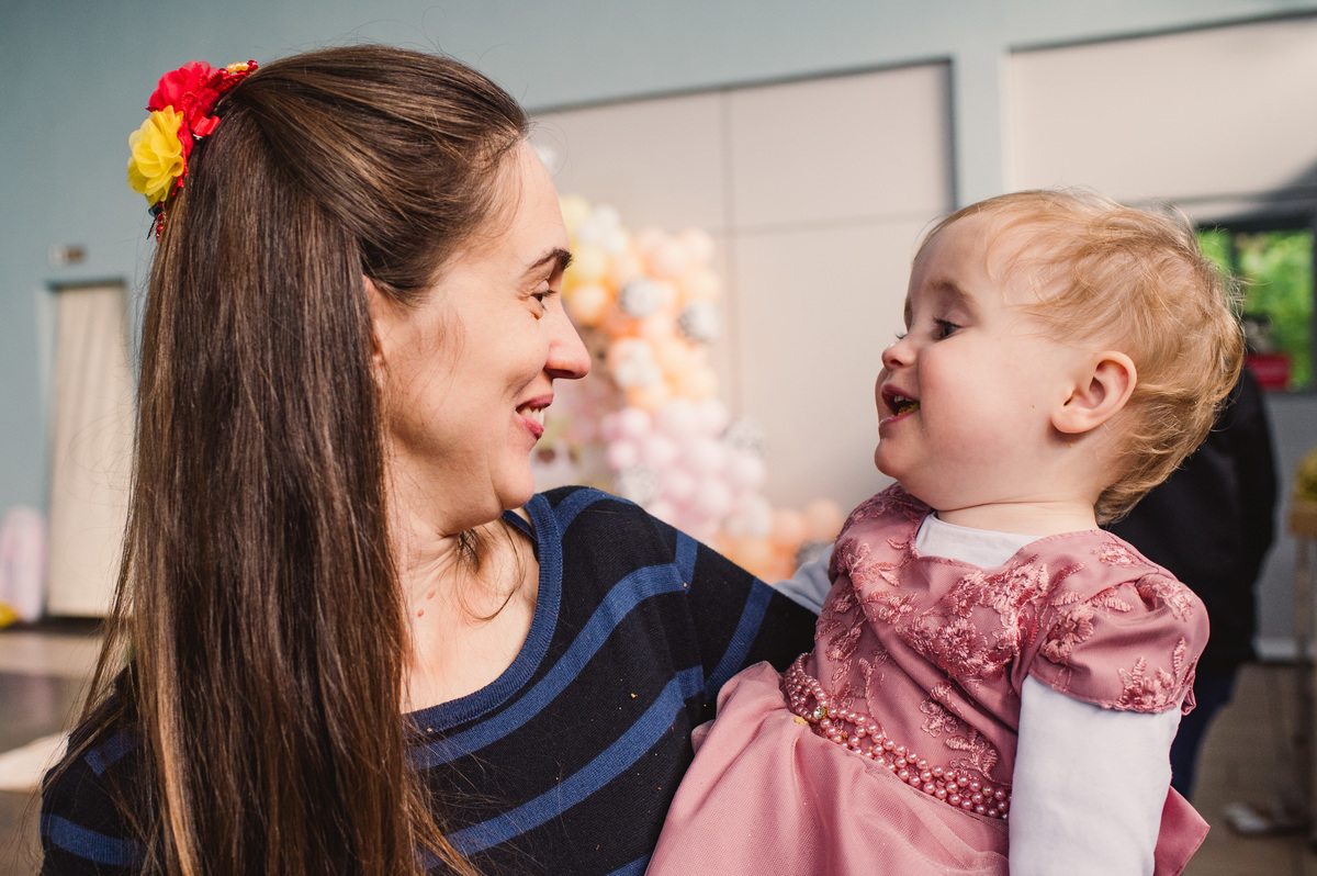 Festa de aniversário infantil em Brochier, fotógrafa Claudia Wallauer, criança no colo da mãe bem sorridente