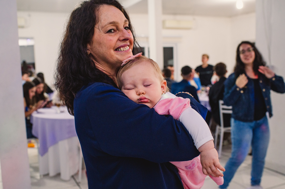 Bebê dormindo no colo da avó na festa de Confirmação