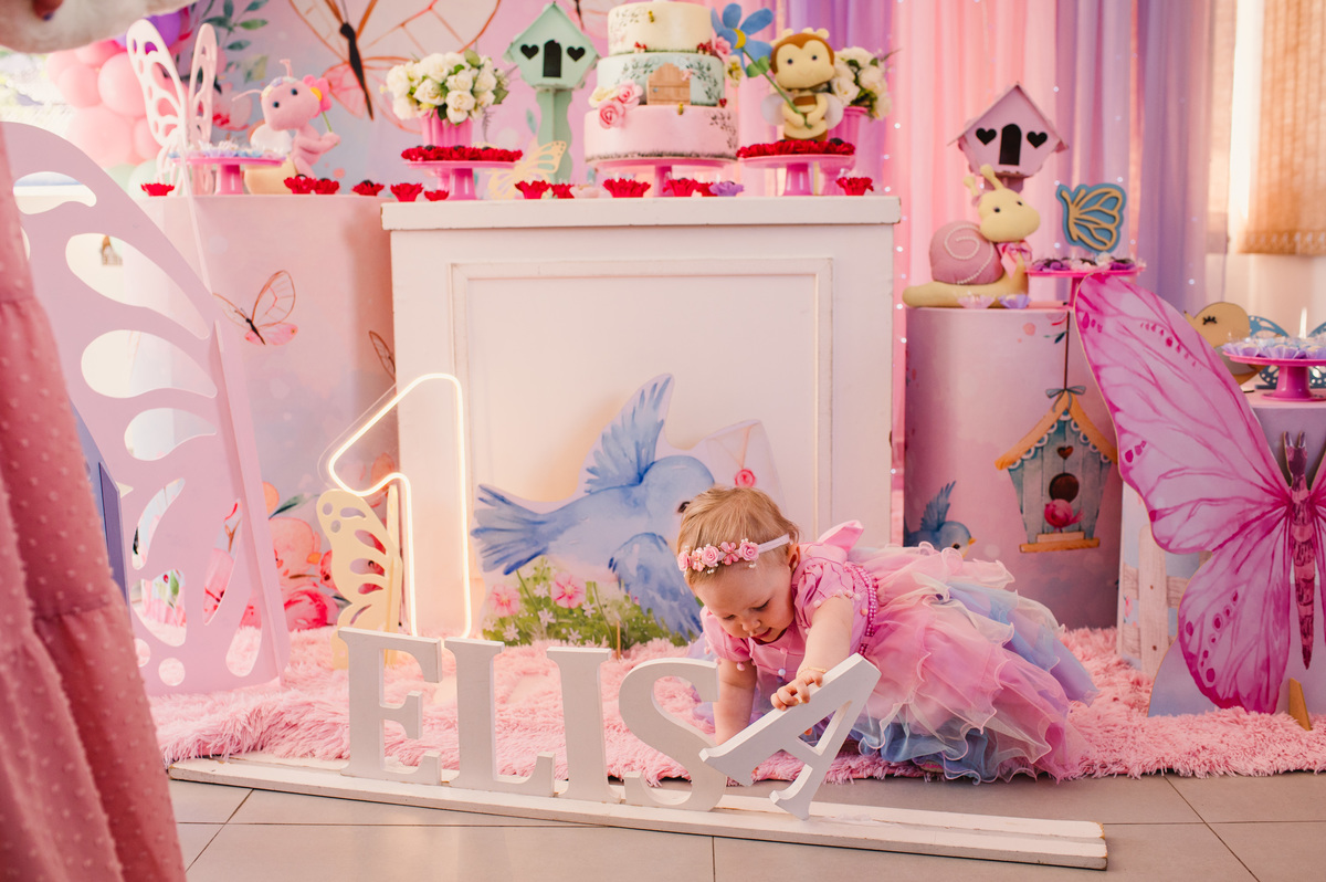 Festa de aniversário de um aninho na Schubert Haus - fotógrafa Claudia Wallauer - foto da criança em frente à decoração de borboleta diversão garantida fest