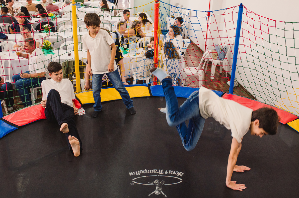 Festa de Confirmação no Centro Evangélico Martin Luther - Montenegro - RS - crianças e adolescentes brincando e adultos conversando ao fundo