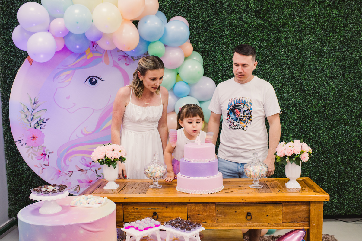 Festa de aniversário infantil, hora de assoprar a velinha, mesa decorada de unicórnio