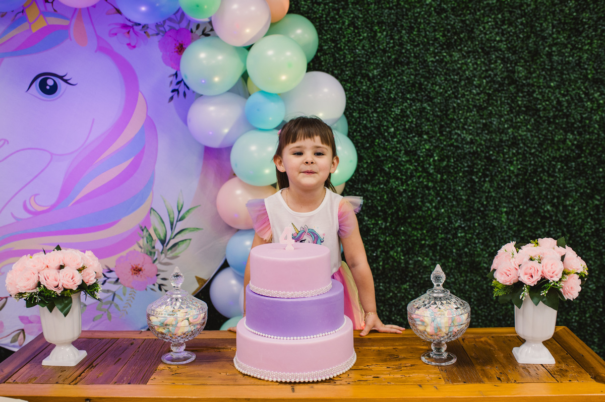 Festa de aniversário infantil, decoração de unicórnio, criança na mesa decorada