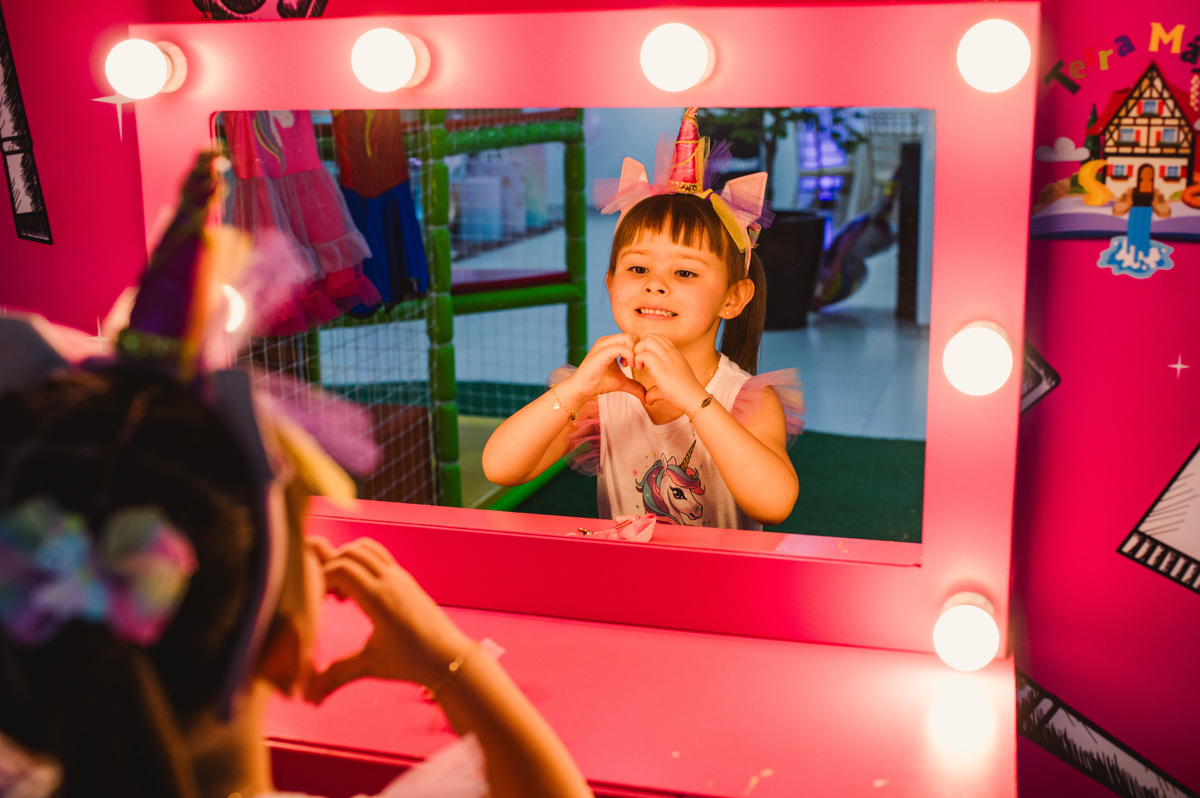 Festa de aniversário infantil, criança no camarim fazendo coração com as mãos