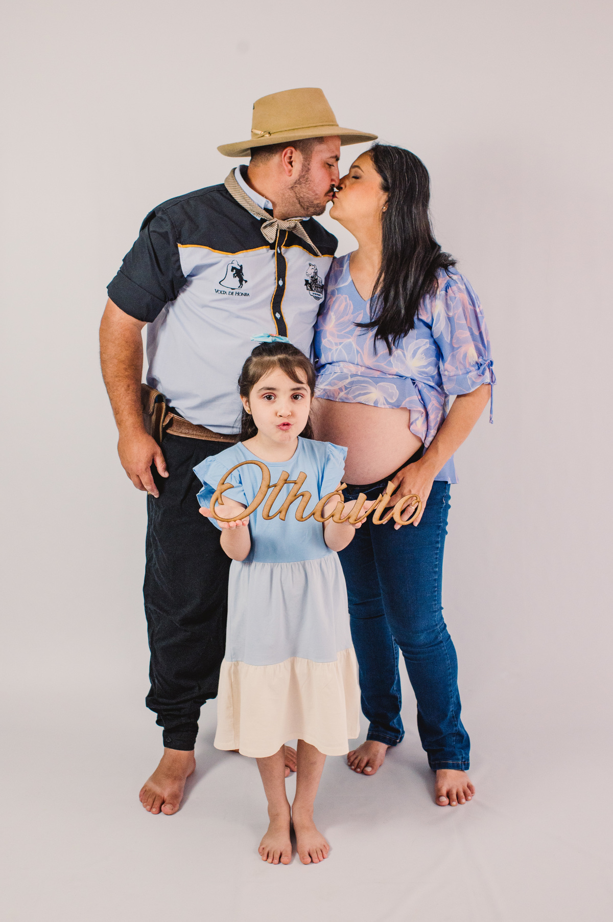 Ensaio de gestante em estúdio, foto com beijo dos pais e o nome do bebê