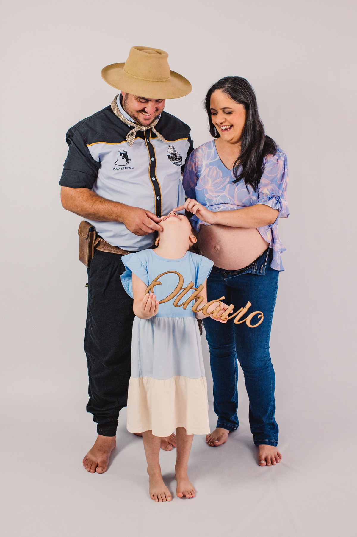 Ensaio de gestante em estúdio, foto espontânea, pais fazendo carinha na irmã