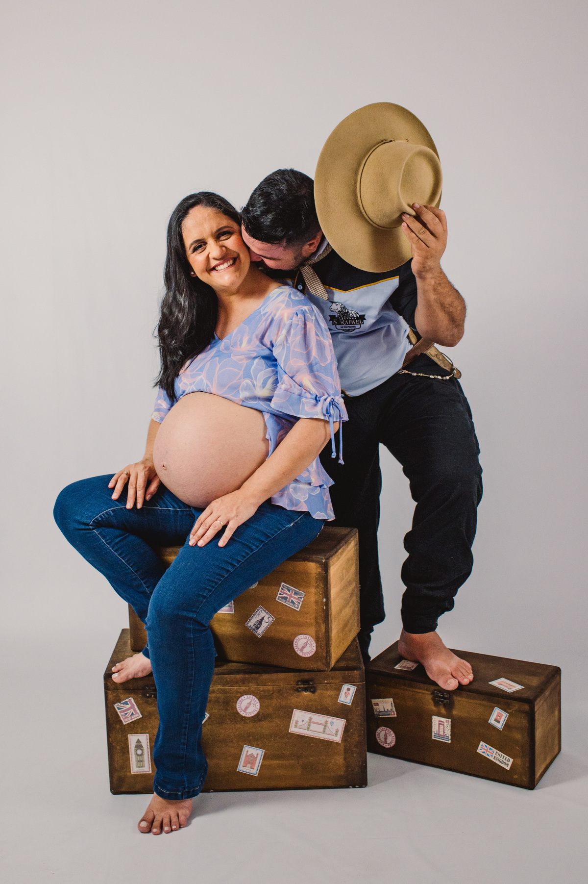 Ensaio de gestante em estúdio, foto do casal com chapéu
