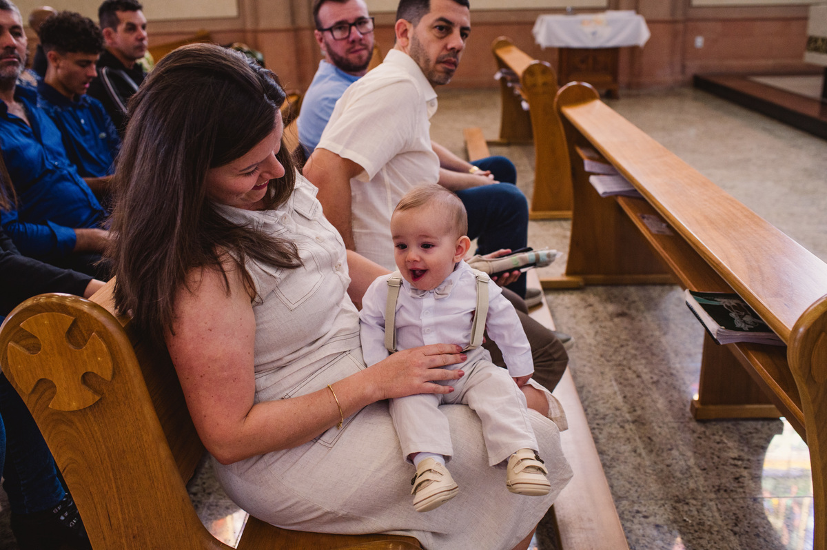 Fotos de batismo na Catedral de Montenegro - Fotógrafa Claudia Wallauer - criança feliz no inicio da missa