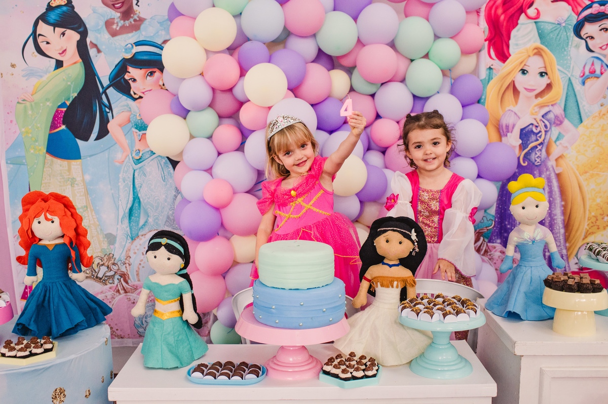 Festa de aniversário de Princesas, convidados fantasiados, fotógrafa Claudia Wallauer, criança mostrando a vela de anos na mesa decorada 
