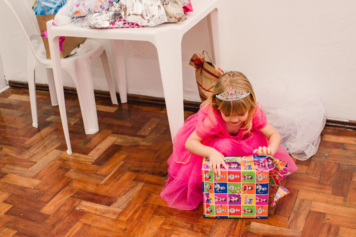 Festa de aniversário de Princesas, convidados fantasiados, fotógrafa Claudia Wallauer, criança abrindo os presentes