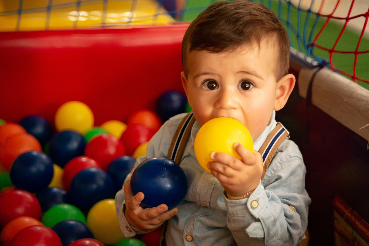 Menino de um aninho brincando na piscina de bolinhas