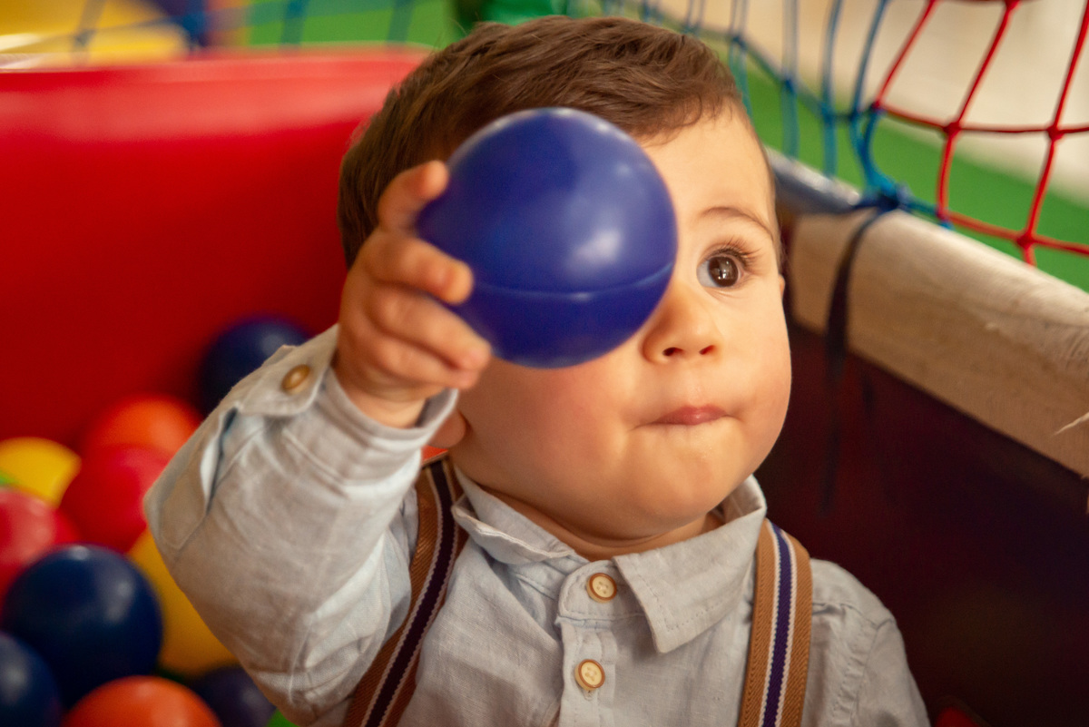 Menino de um aninho brincando na piscina de bolinhas