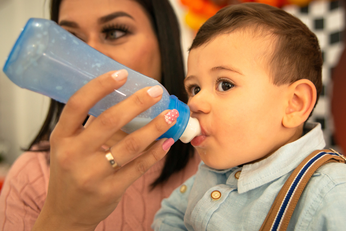 Menino tomando mamadeira na festa de um aninho