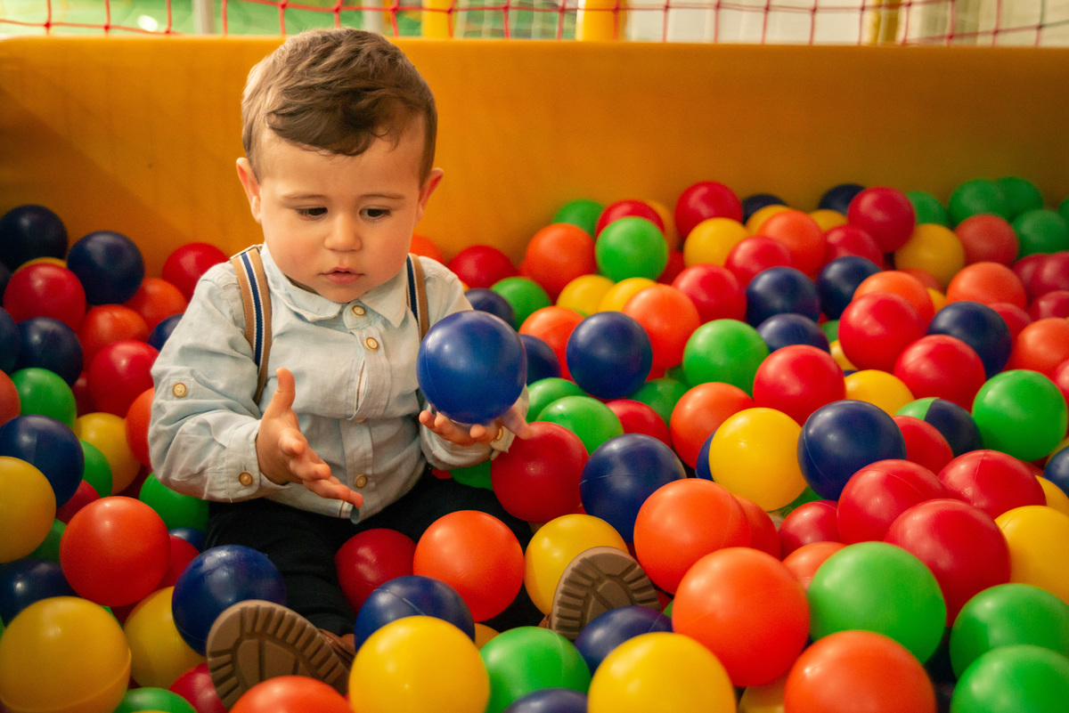 Menino de um aninho brincando na piscina de bolinhas