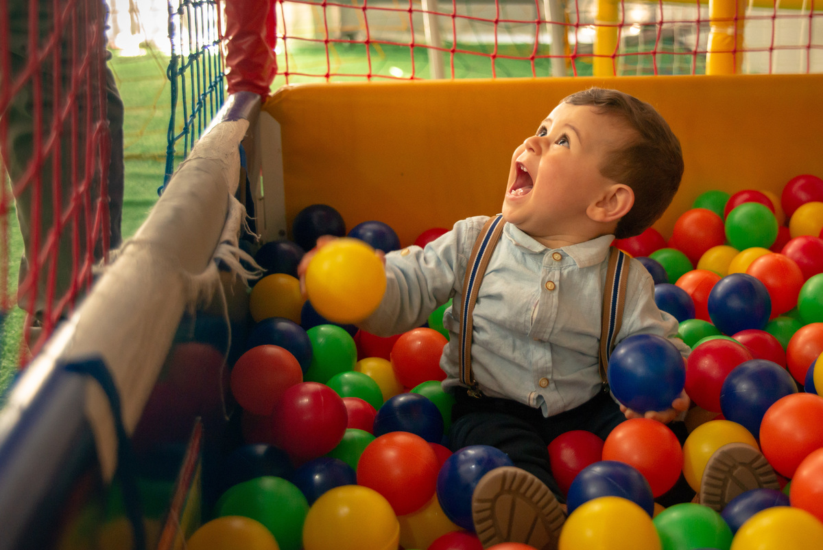 Menino de um aninho brincando na piscina de bolinhas