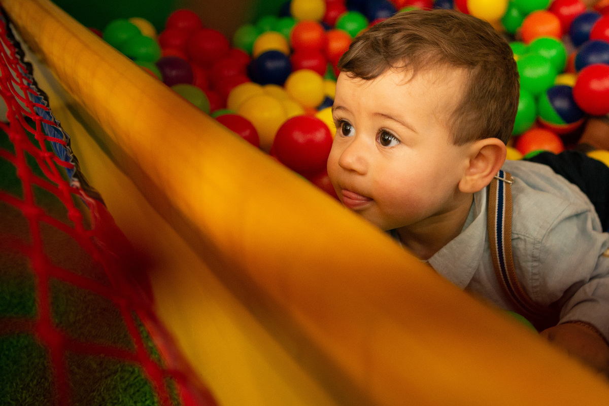 Menino de um aninho brincando na piscina de bolinhas