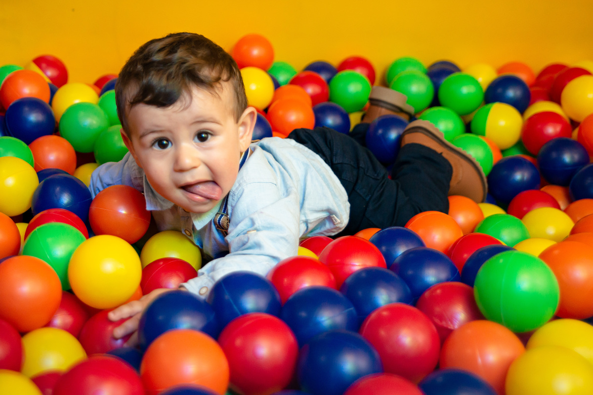 Menino de um aninho brincando na piscina de bolinhas