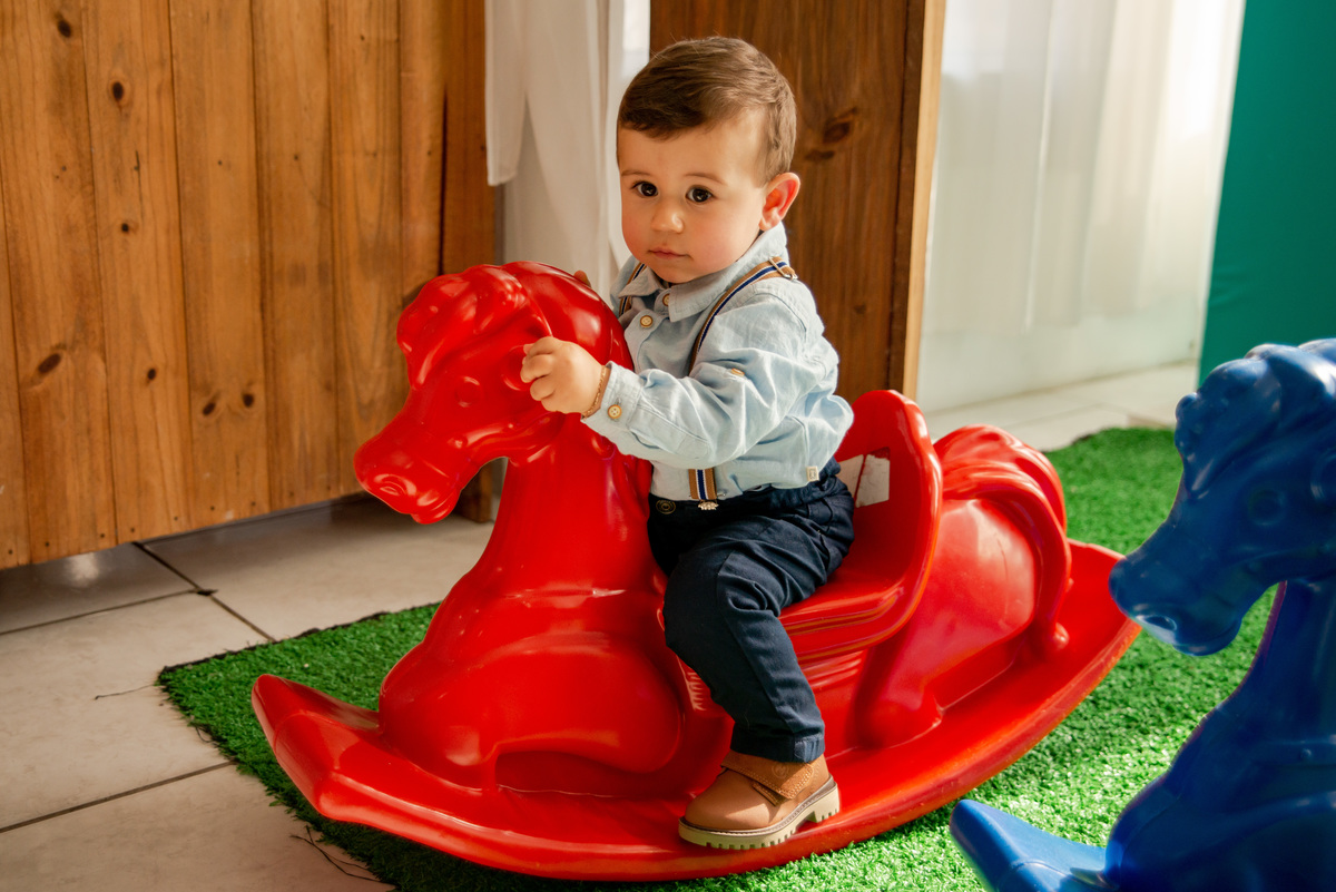 Festa de aniversário de um aninho, menino brincando num cavalinho