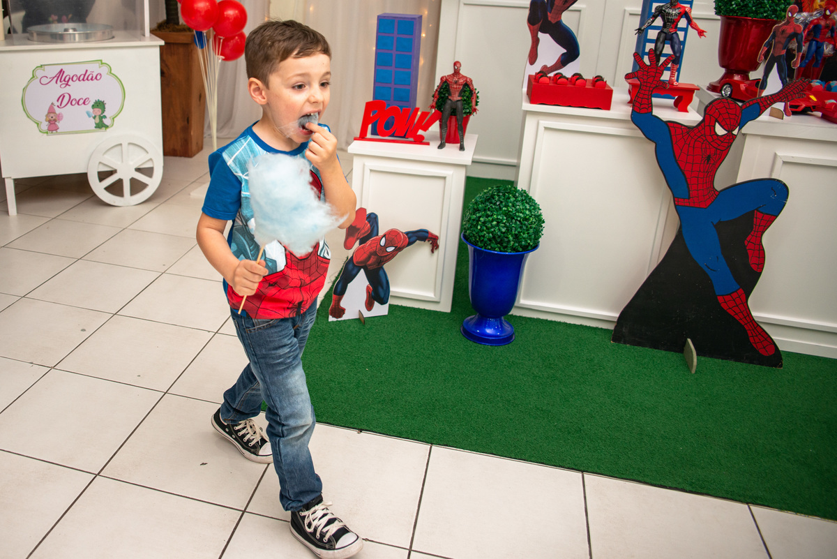 menino comendo algodão doce na festa de aniversário infantil do homem aranha