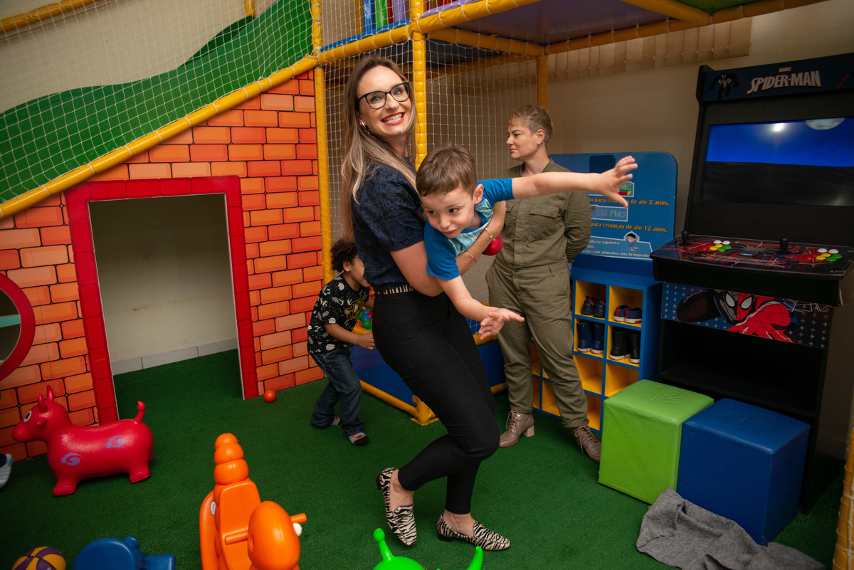 mãe carregando filho em casa de festa infantil em Montenegro 