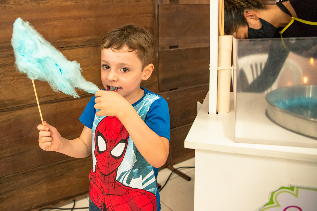 criança comendo algodão doce em festa infantil em casa de festa em Montenegro