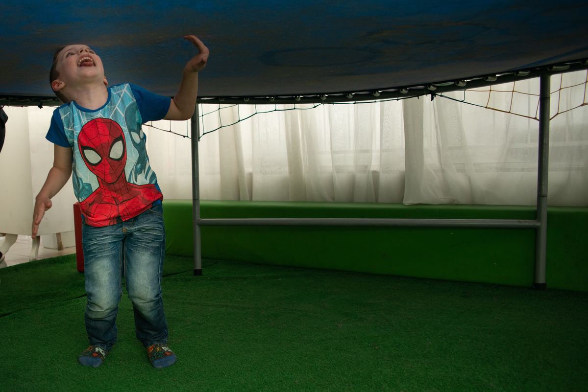 menino em baixo da cama elástica em festa infantil em casa de festa em Montenegro