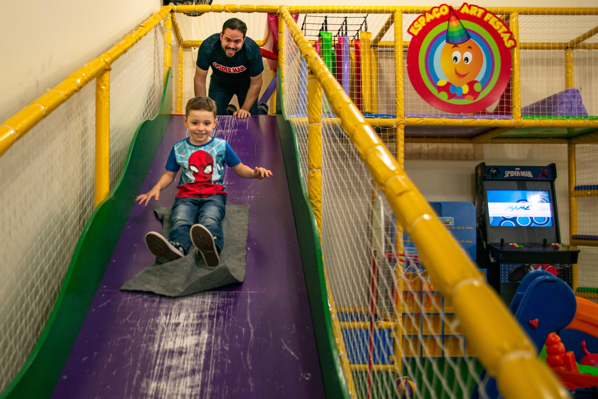 pai e filho em escorregador de casa de festa infantil em Montenegro