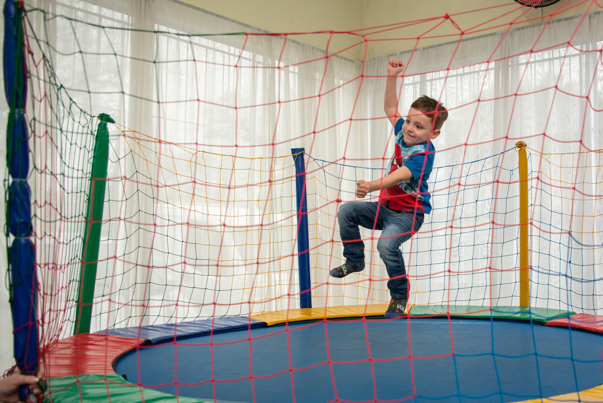 menino pulando na cama elástica