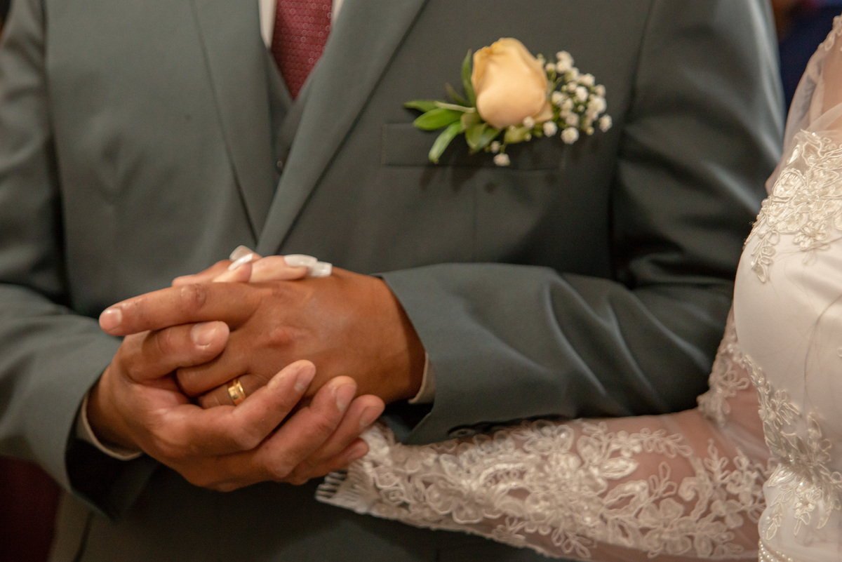 mãos unidas dos noivos no casamento