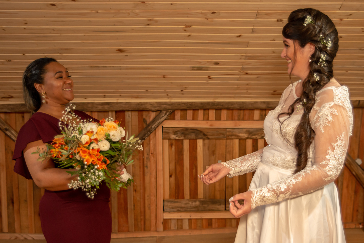 Noiva recebendo o buquê da madrinha