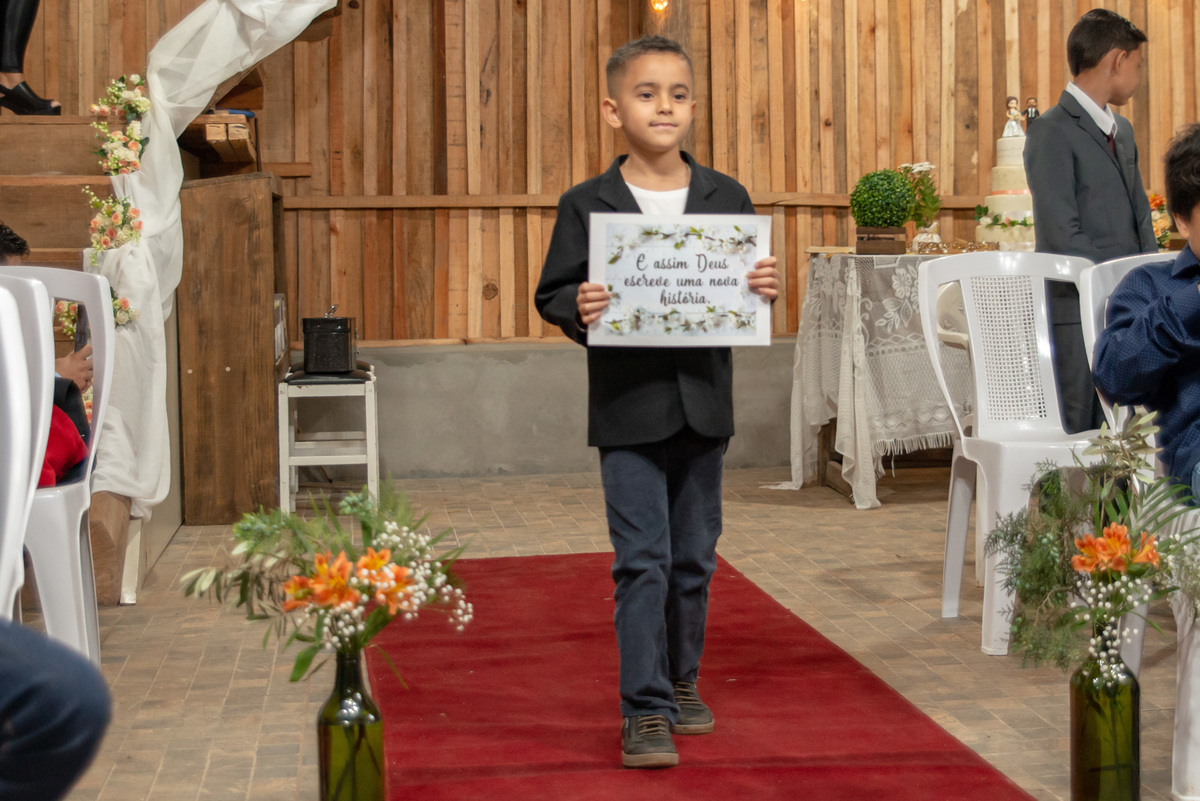 pajem carregando plaquinha no casamento