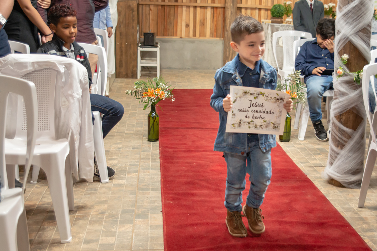 pajem carregando plaquinha no casamento
