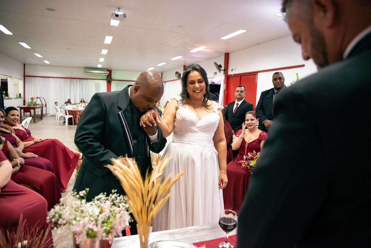 noivo beijando a mão da noiva no altar