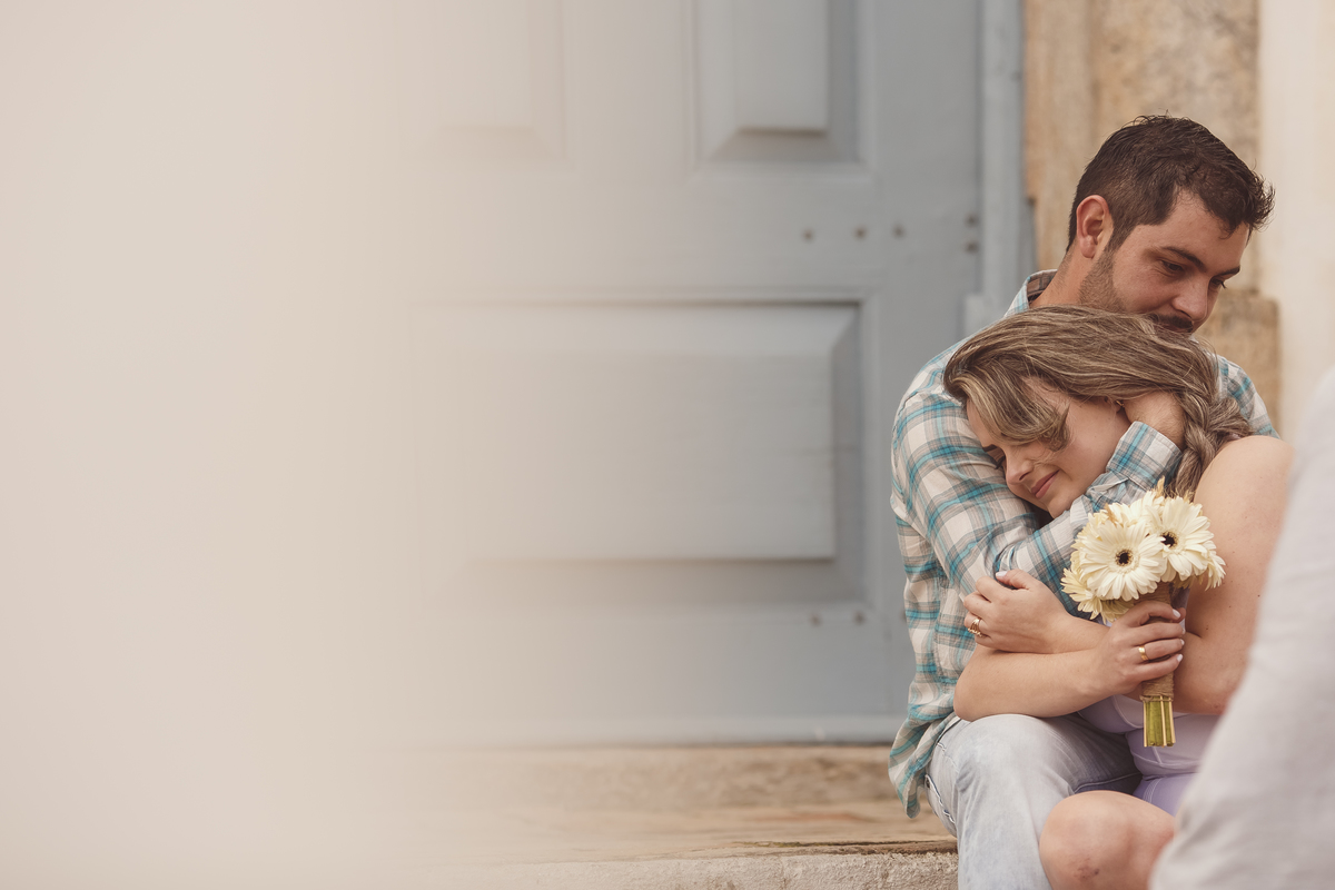 Noivos abraçados na porta da igreja em Jurerê