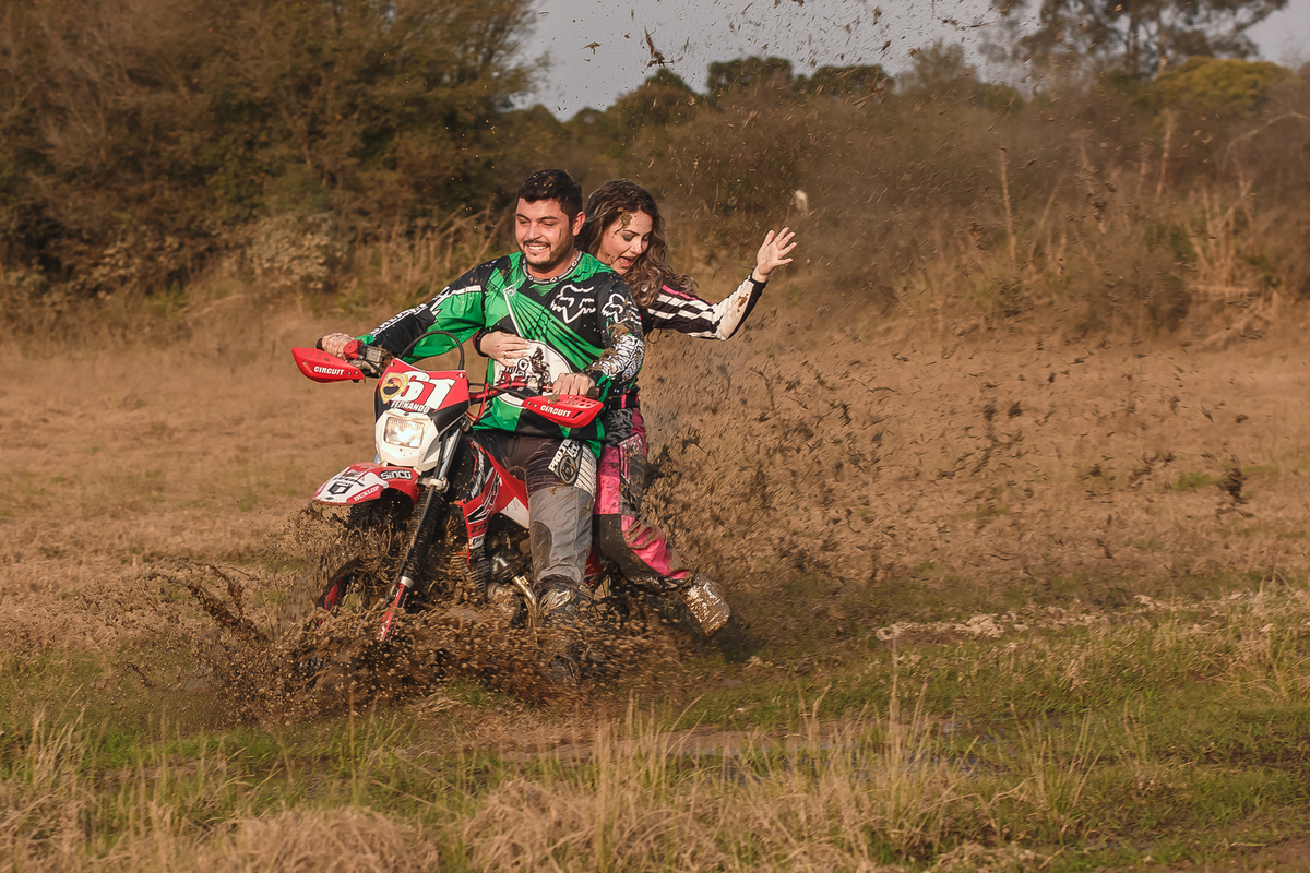 namorados andando de moto na trilha
