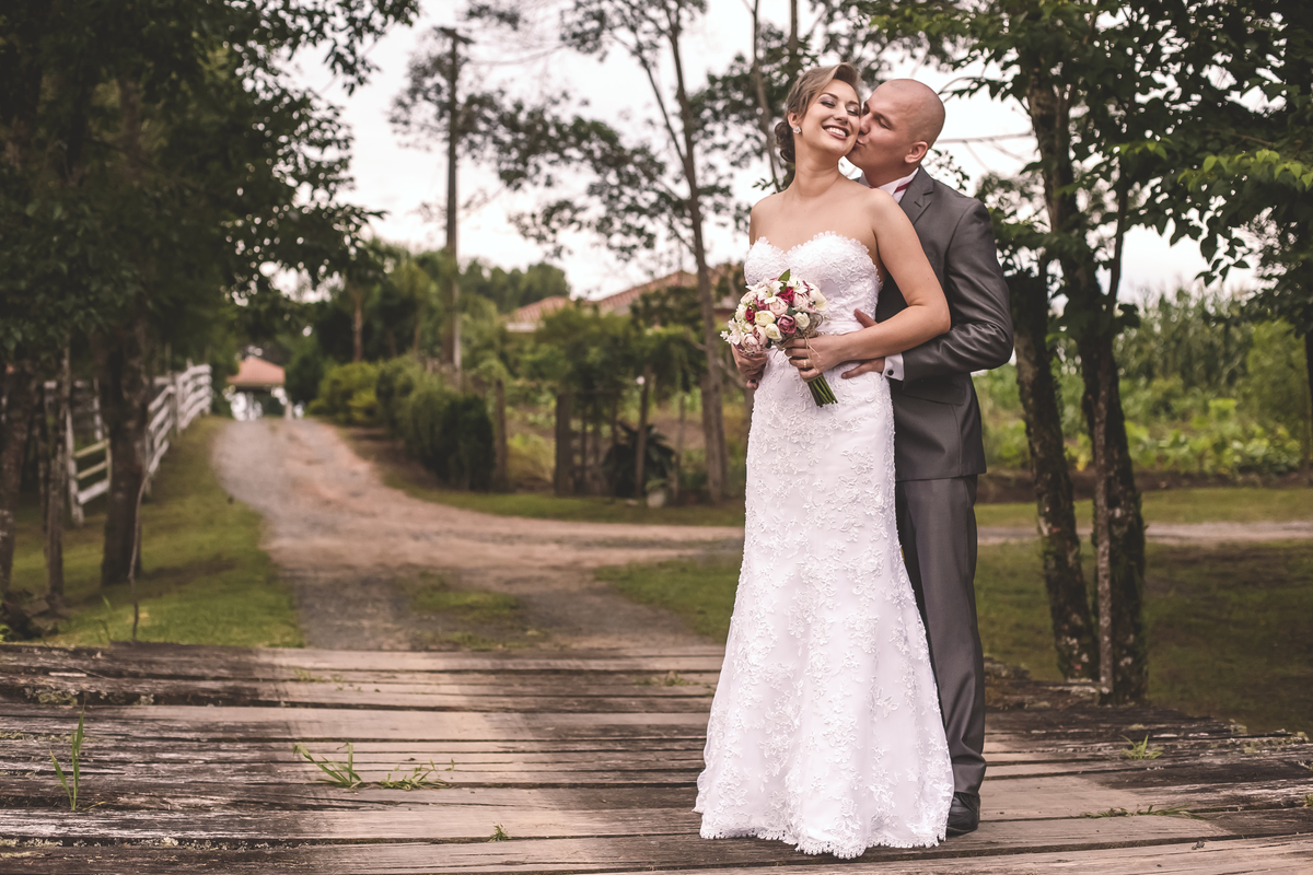 noivo abraçando noiva e beijando seu pescoço