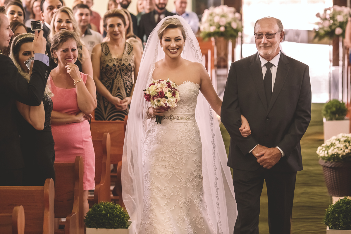 noiva feliz entrando com seu pai na igreja