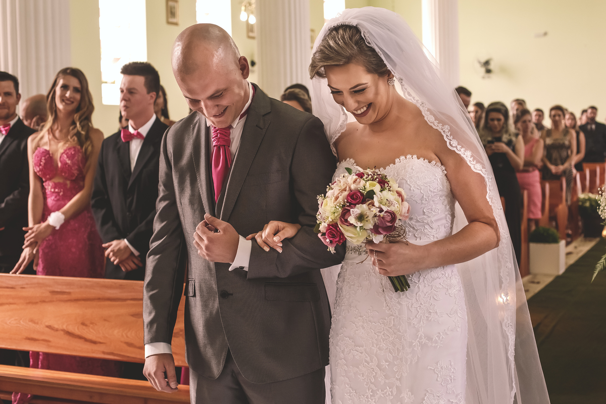 noivos felizes dando risada na igreja em casamento