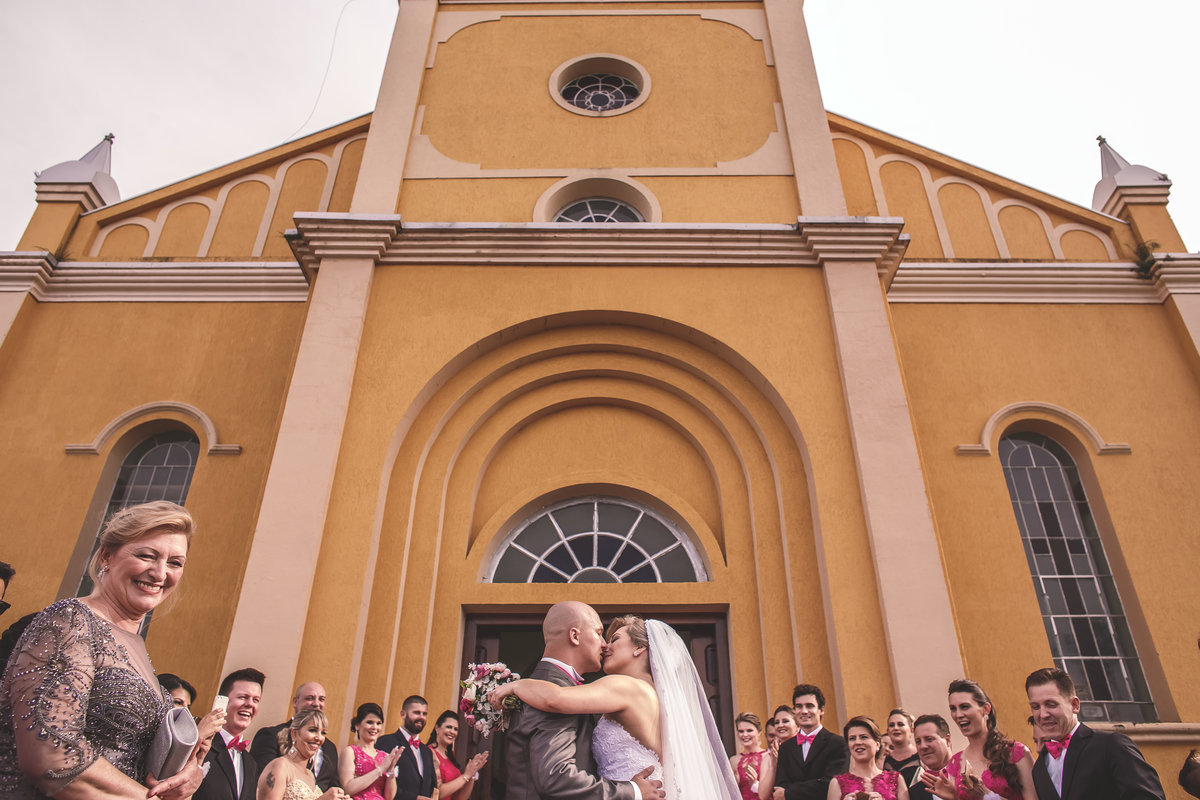 noivos se beijando em frente a igreja em Mallet/PR