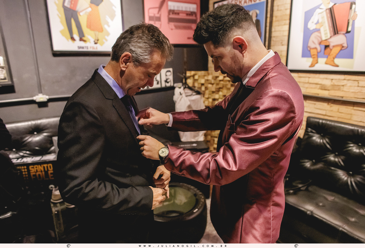 noivo arrumando o terno do pai durante o making of em irati, paraná
