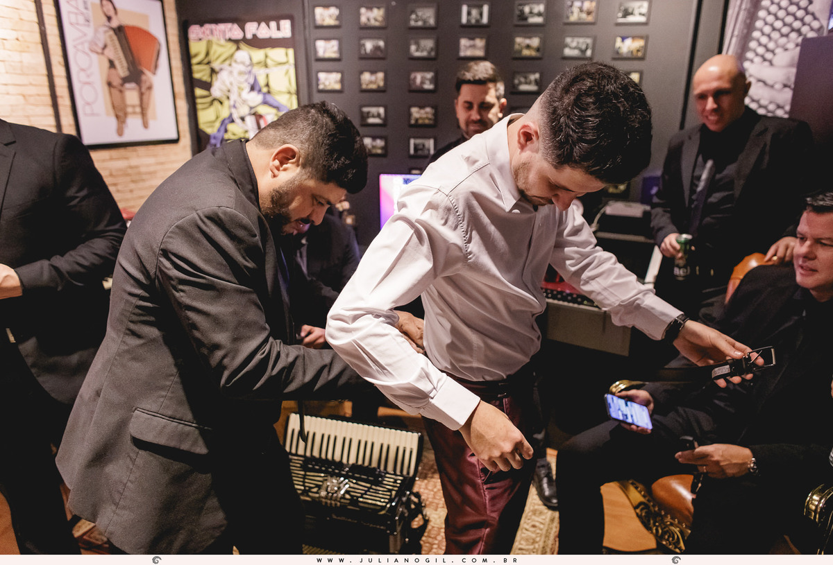 padrinho ajustando o cinto no noivo