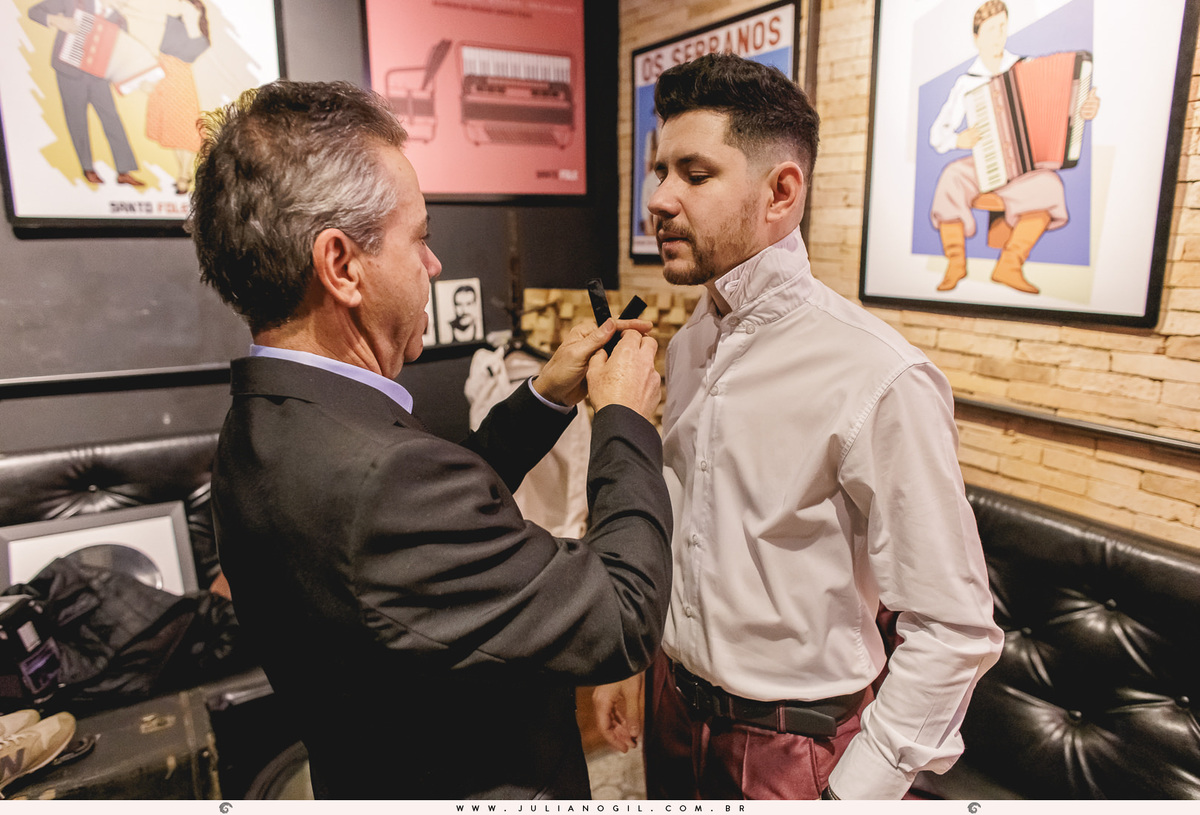 pai do noivo ajustando a gravata no filho