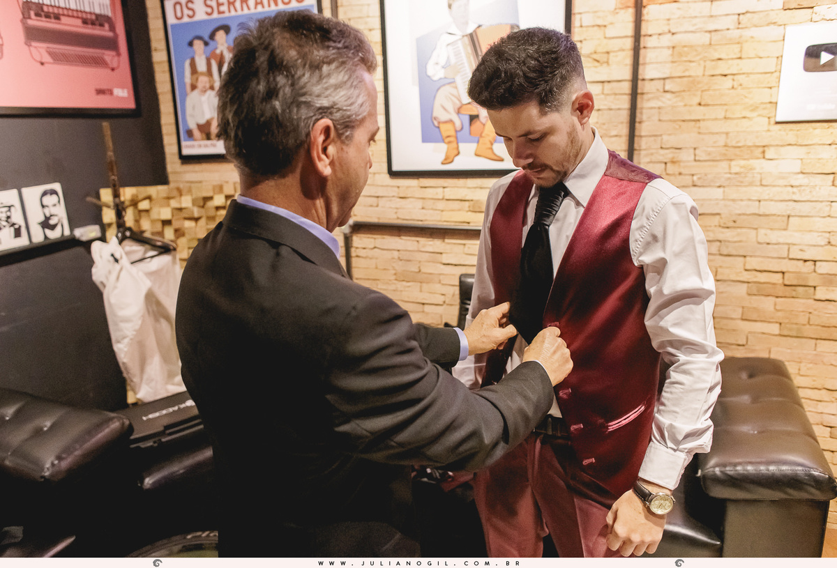 pai do noivo ajustando o colete no filho