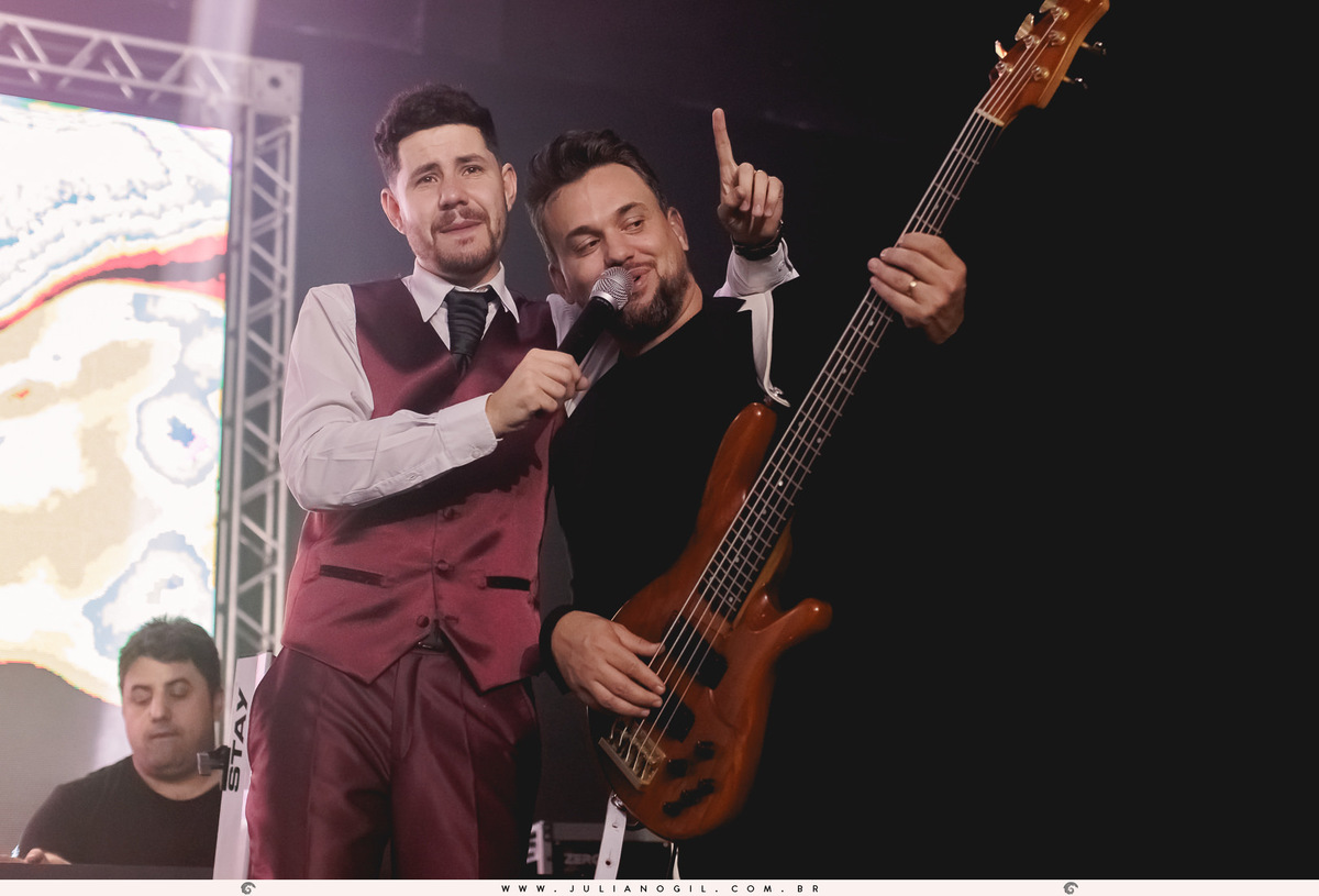 noivo cantando no palco com padrinho