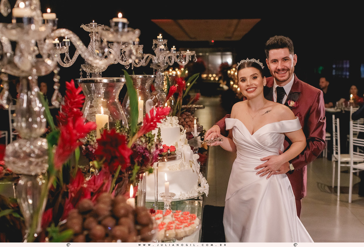 noivos em frente a mesa de doces e bolo na recepção de casamento no espaço santo fole